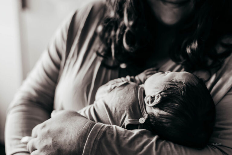 usiness owner on maternity leave holding her newborn while stepping away from daily business operations.